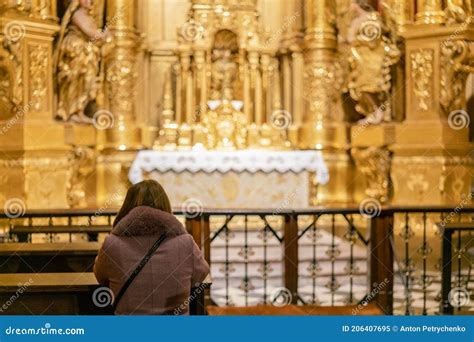 Persona in preghiera davanti all’altare di un santo