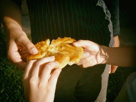 Mani che condividono pane con affamati